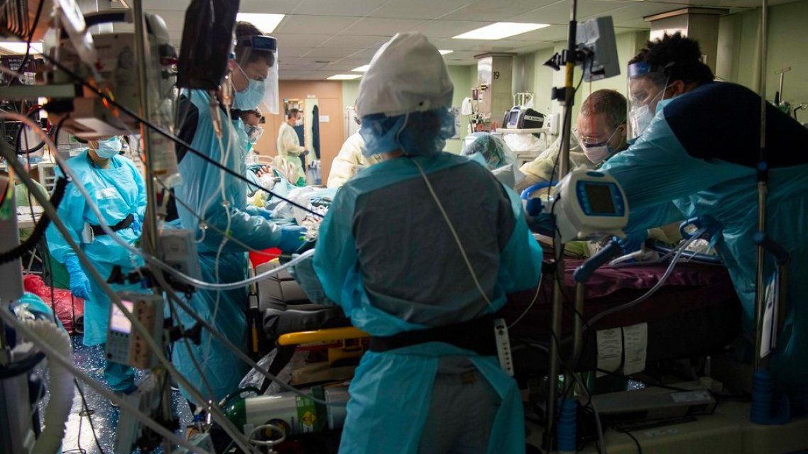Bilde fra en intensivavdeling med utstyr og ansatte kledd i fullt smittevernsutstyr