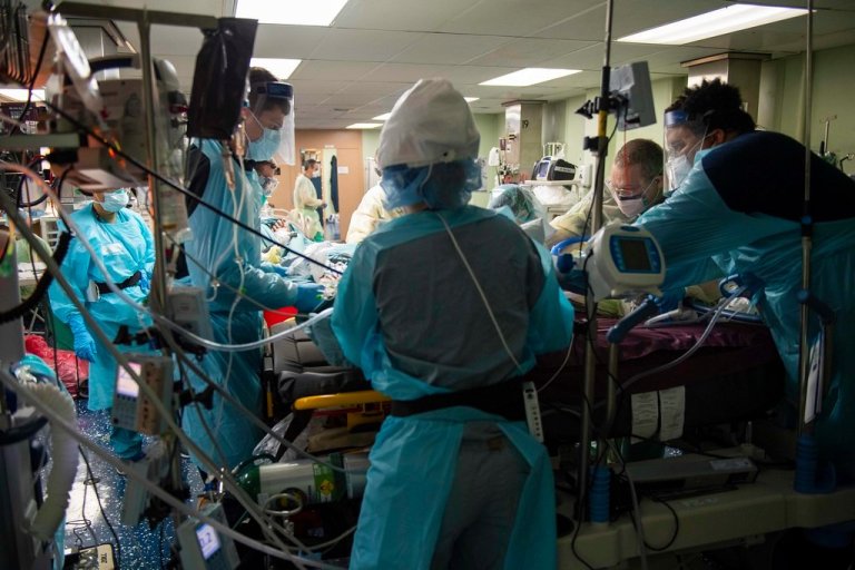 Bilde fra en intensivavdeling med utstyr og ansatte kledd i fullt smittevernsutstyr
