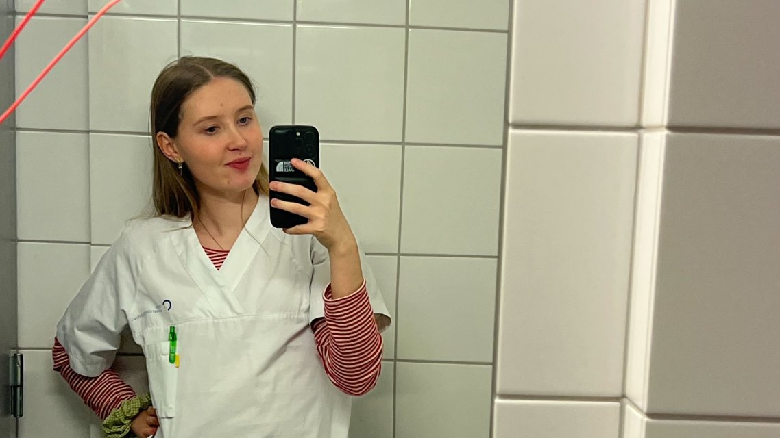 Speilselfie av sykepleierstudent Stella Braathen Reif i uniform på badet