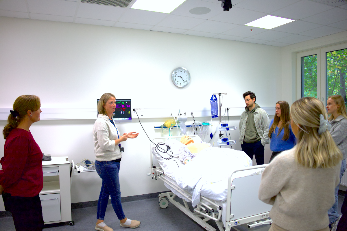 Personer står rundt en sykeseng i Klinisk læringslab
