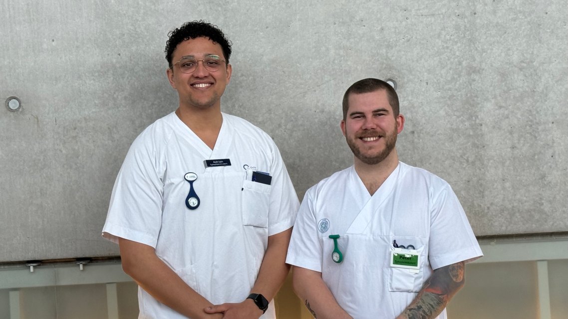 To mannlige studenter i sykepleieruniform smilende